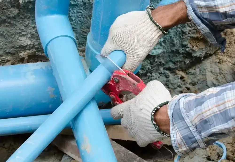 Plumber-Cutting-Blue-PVC-Pipe